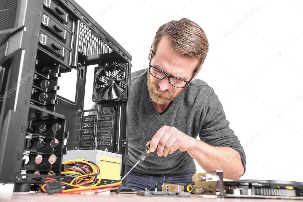 Tecnico che ripara un computer desktop su un banco da lavoro